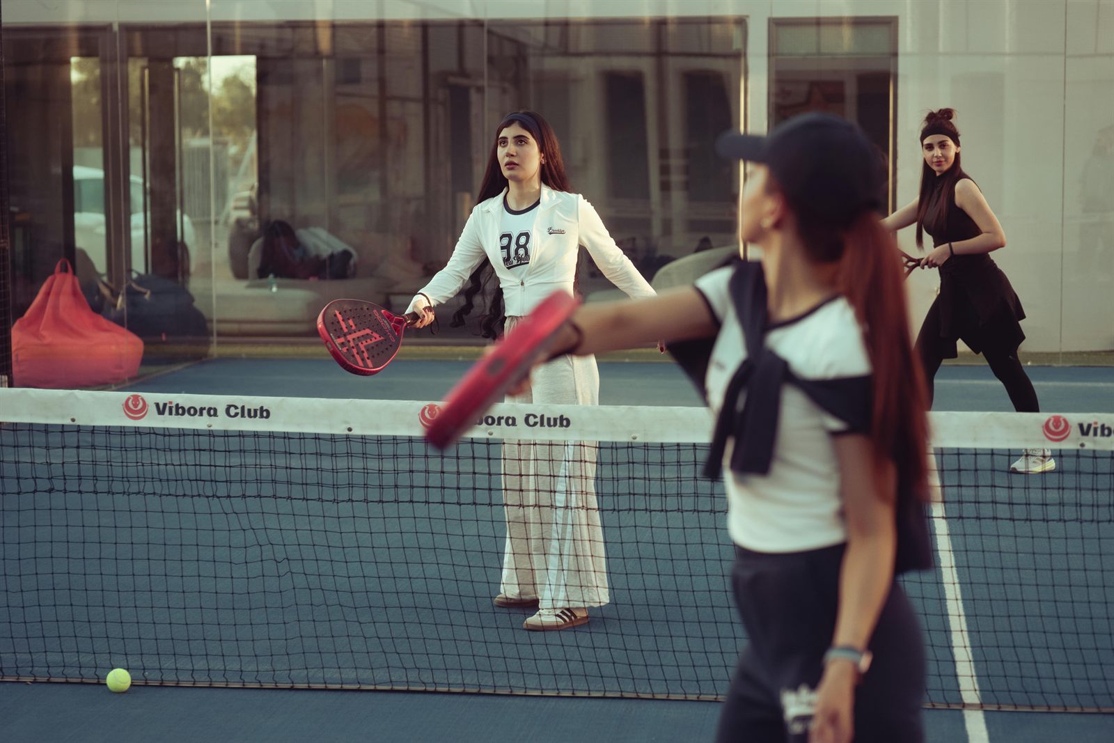Människor spelar padel tillsammans på en öppen utomhusbana.