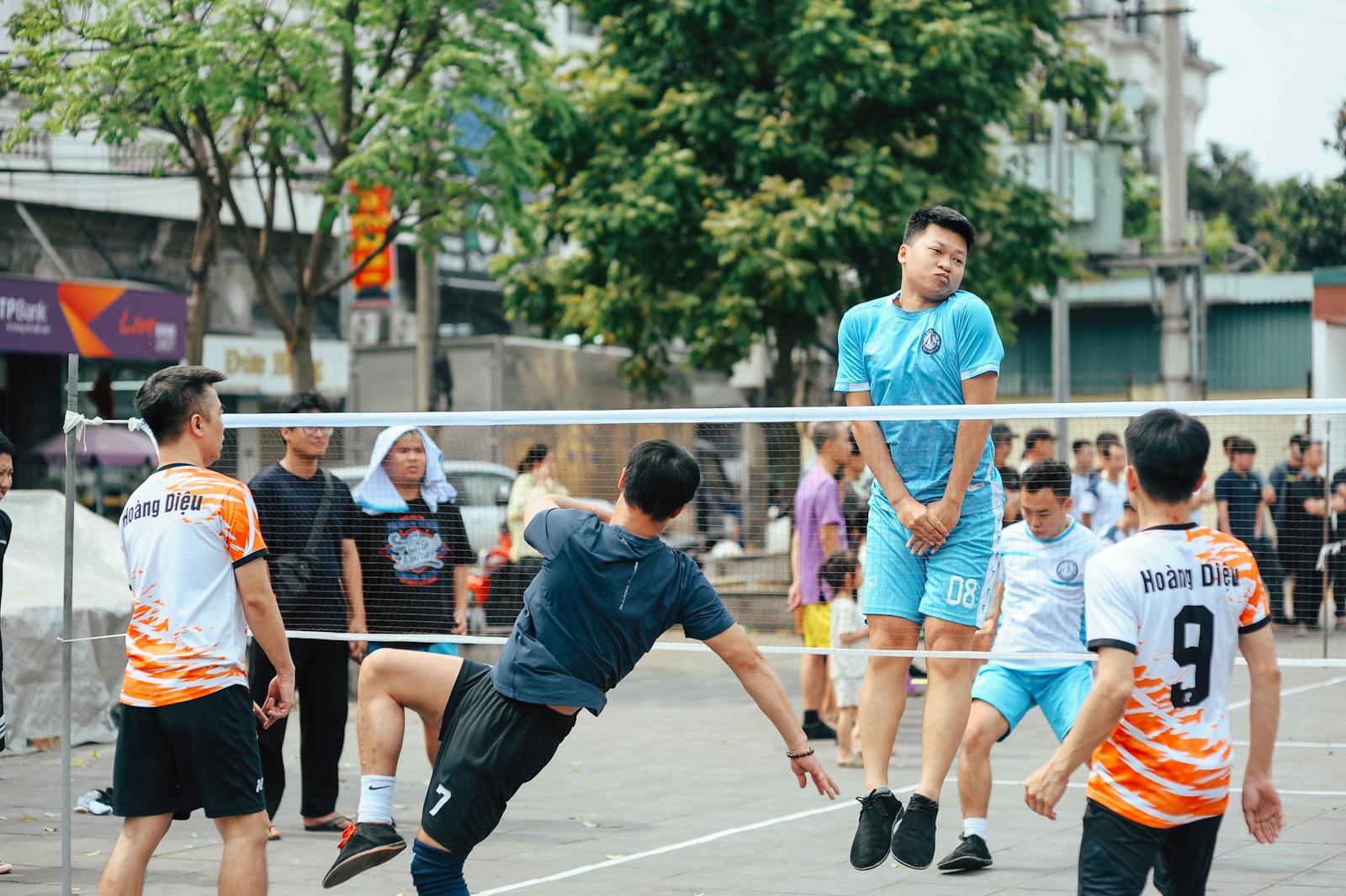 Spelare möts i ett futnetliknande bollspel på en offentlig utomhusplan.